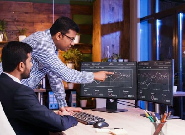 Analyzing data on computer screens.